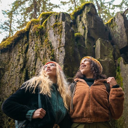 Kaksi nuorta naista seisoo korkean rotkon edessä Tahkolla