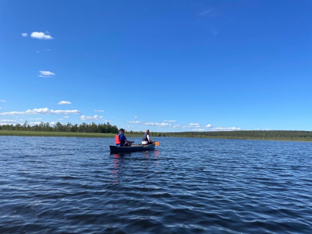 Kaksi miestä Lapissa melomassa keskellä järveä.