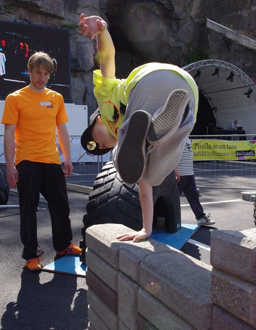 Lapsi Parkour Akatemian valmennattavana hyppäämässä tiiliaidan ylitse