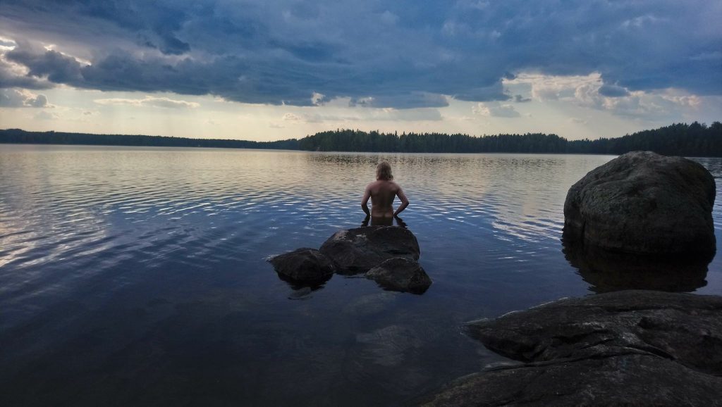 Nuori mies menossa uimaan, katse kohti järveä